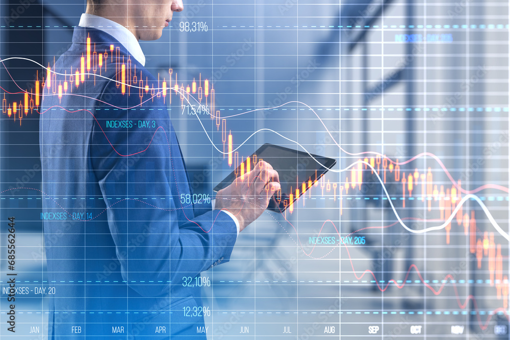 Focused businessman with tablet overlayed with stock market decline charts Focused businessman with tablet overlayed with stock market decline charts