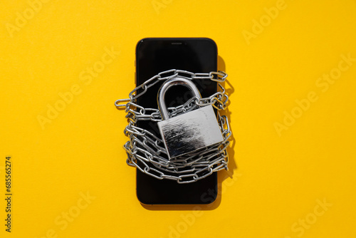 The smartphone is encased in a chain with a lock