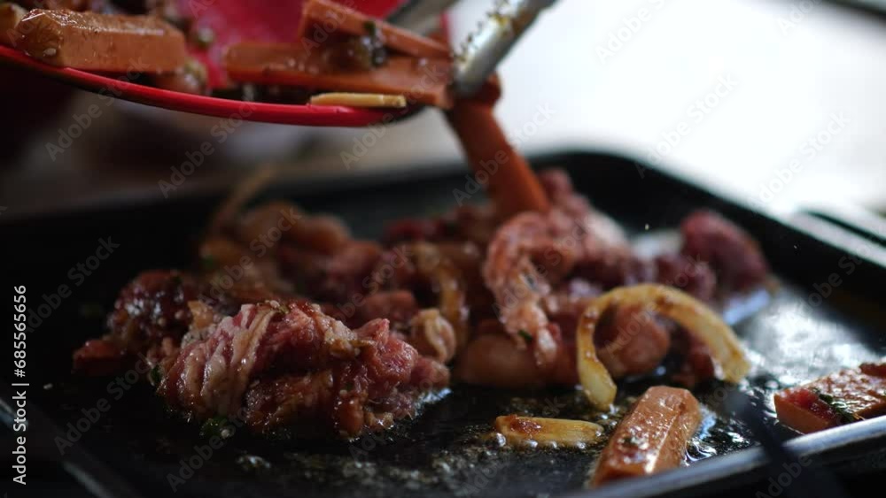 Selective focus raw beef slice for barbecue japanese style, yakiniku. Meats are being cooked on stove. Selective focus korea BBQ style restaurant. Selective focus raw beef slice for barbecue japanese style, yakiniku. Meats are being cooked on stove. Selective focus korea BBQ style restaurant.
