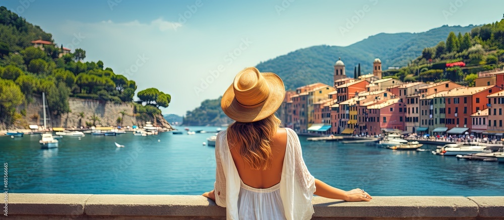 Tourist girl enjoying view of picturesque village in Portofino Italy copy space image - obrazy, fototapety, plakaty 