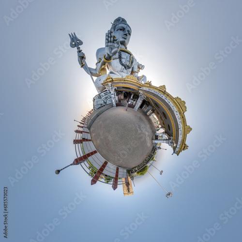 tallest hindu shiva statue in india on mountain near ocean on little planet in blue sky, transformation of spherical 360 panorama. Spherical abstract view with curvature of space.