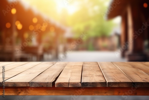 empty wooden table top for product display montages with blurred farm barns and buildings background