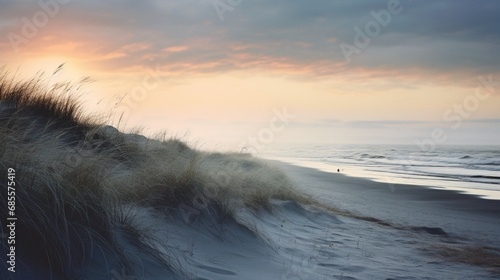 An early morning coastal landscape with dew-covered dunes and a pastel sunrise reflecting on a calm sea.