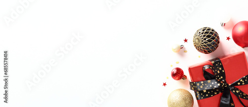 Stylish Christmas banner design with red gift box, baubles, confetti on white background. Top view with copy space