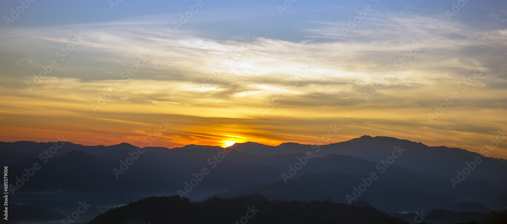 Sun sets on the horizon and there are big, beautiful mountains. Sun sets on the horizon and there are big, beautiful mountains.