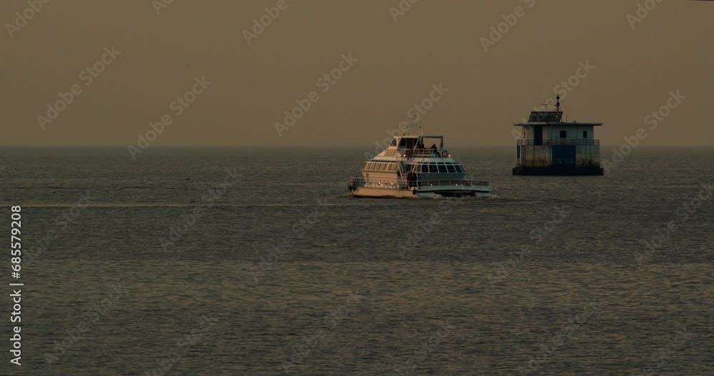 A beautiful yacht with an Argentine flag sails on the sea at sunset, waves diverge from the ship, evening A beautiful yacht with an Argentine flag sails on the sea at sunset, waves diverge from the ship, evening