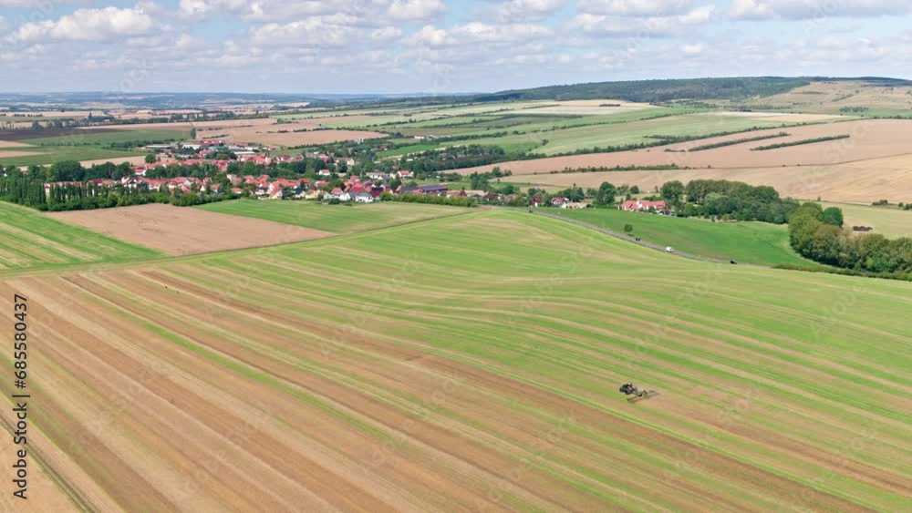 Machines till the fields for the coming harvest year. Wide angle drone shot. Machines till the fields for the coming harvest year. Wide angle drone shot.