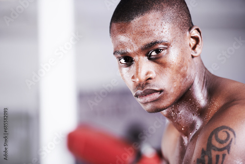 Man, boxer and portrait in gym, sweat and face for workout, boxing and strong. Exercise, sports and training for power, self defense and concentration for challenge, mma and fighting skills photo