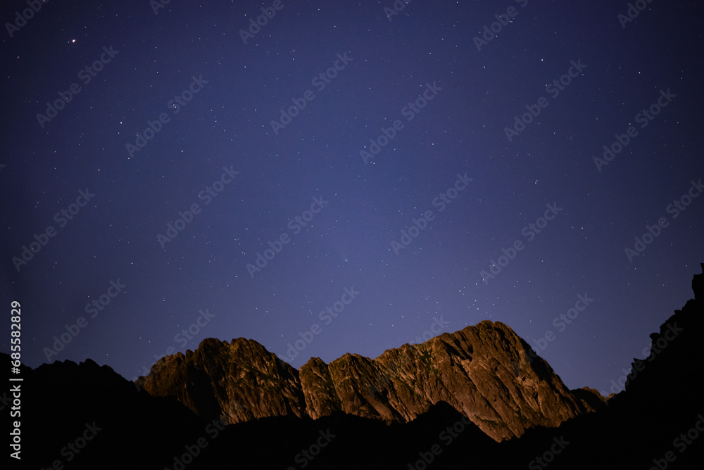 Night landscape with starry sky seen from rocky mountains