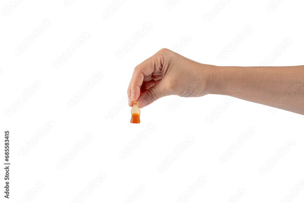 Cola flavored gummy jellies in the shape of cola bottles in hand,isolated on transparent background. Cola flavored gummy jellies in the shape of cola bottles in hand,isolated on transparent background.