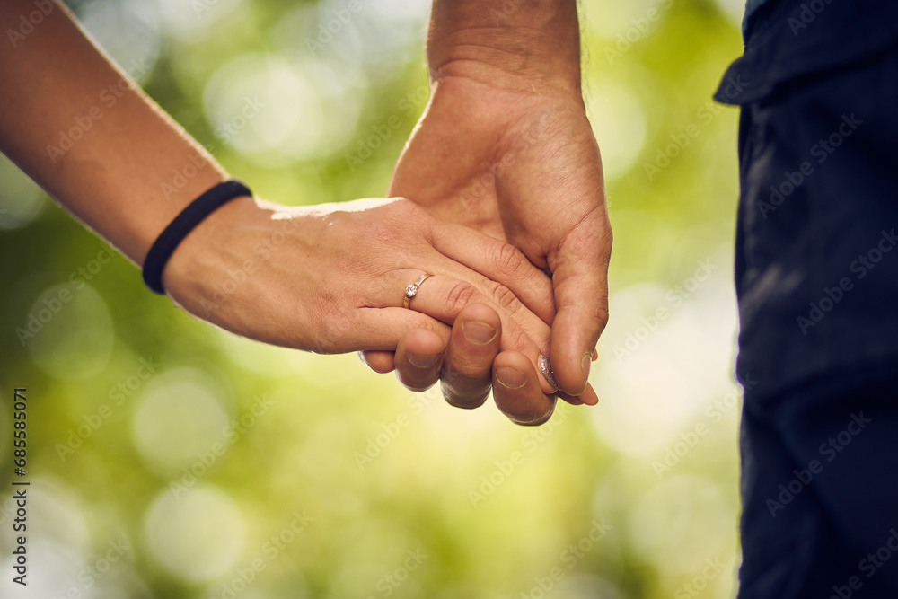 Close-up of young people holding each other tenderly while walking in the park Close-up of young people holding each other tenderly while walking in the park