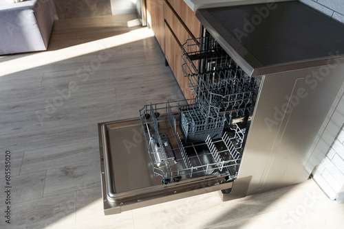 Open dishwasher with clean dishes in the white kitchen.