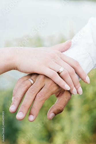 Wedding rings on the hands of the bride and groom. Female and male hand holding