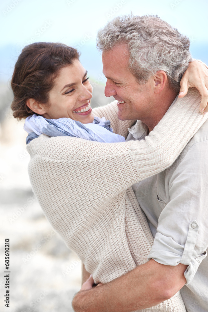 Fototapeta premium Couple, face and laughing outdoor with hug for romance, love and relationship in nature with date. Mature, man and woman or embrace with happy, playful and joy for bonding, honeymoon and support