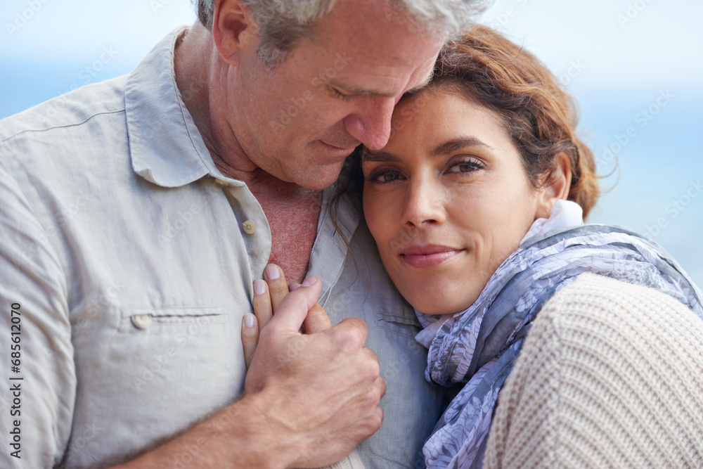 Fototapeta premium Couple, face and smile outdoor with hug for romance, love and relationship in nature with date. Mature, man and woman or embrace with happy, marriage and joy for bonding, honeymoon and support