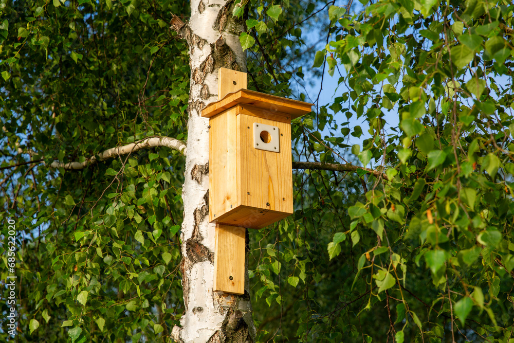 New wooden bird house in the park. New wooden bird house in the park.