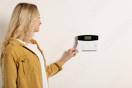 Home security system. Woman using key card indoors photo