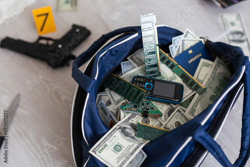 Black duffel bag full of dollar notes in criminal investigation unit, conceptual image photo