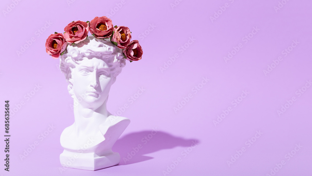 Card with an artificial statue of David in a wreath of flowers on a purple background. Creative modern web banner with copy space for text