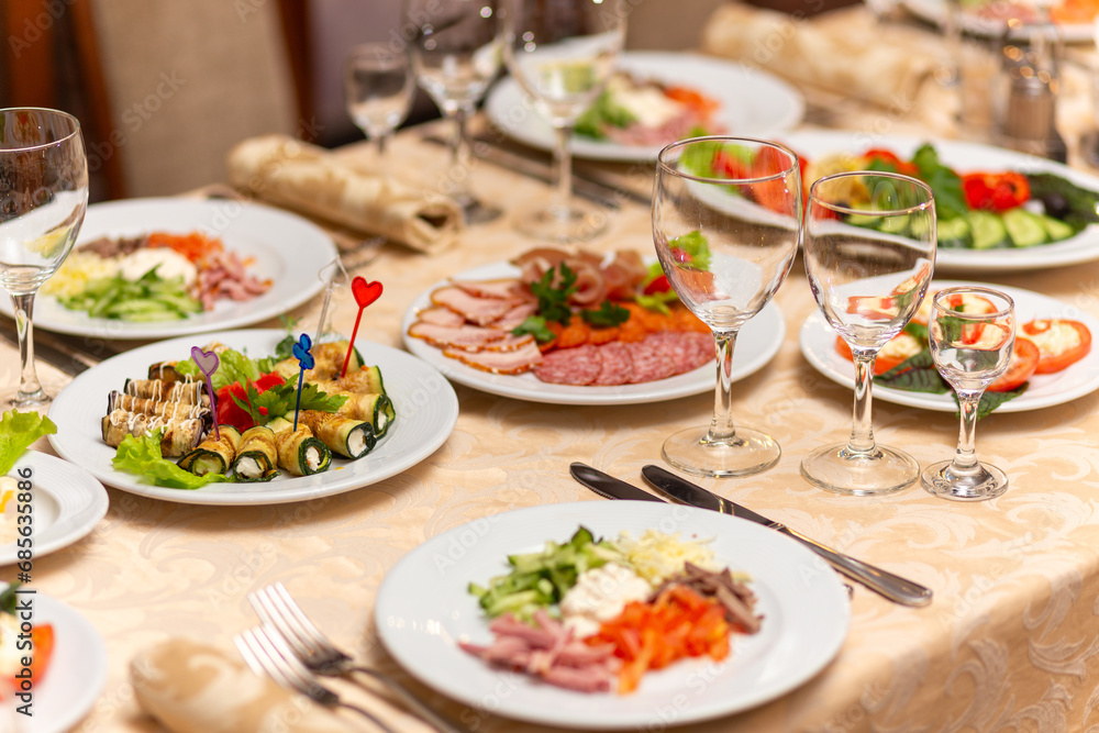 Served festive table with snacks, glasses, glasses, cutlery and napkins for a banquet Served festive table with snacks, glasses, glasses, cutlery and napkins for a banquet