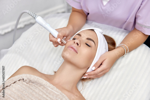 beautiful woman getting microdermabrasion procedure in a beauty spa salon photo