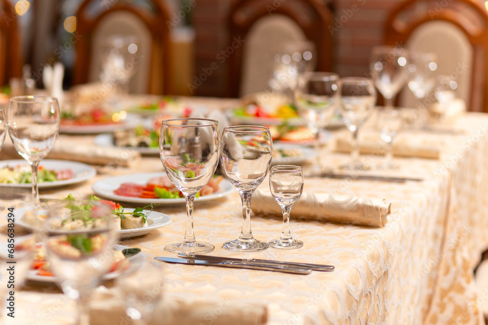 Fototapeta premium Served festive table with snacks, glasses, glasses, cutlery and napkins for a banquet