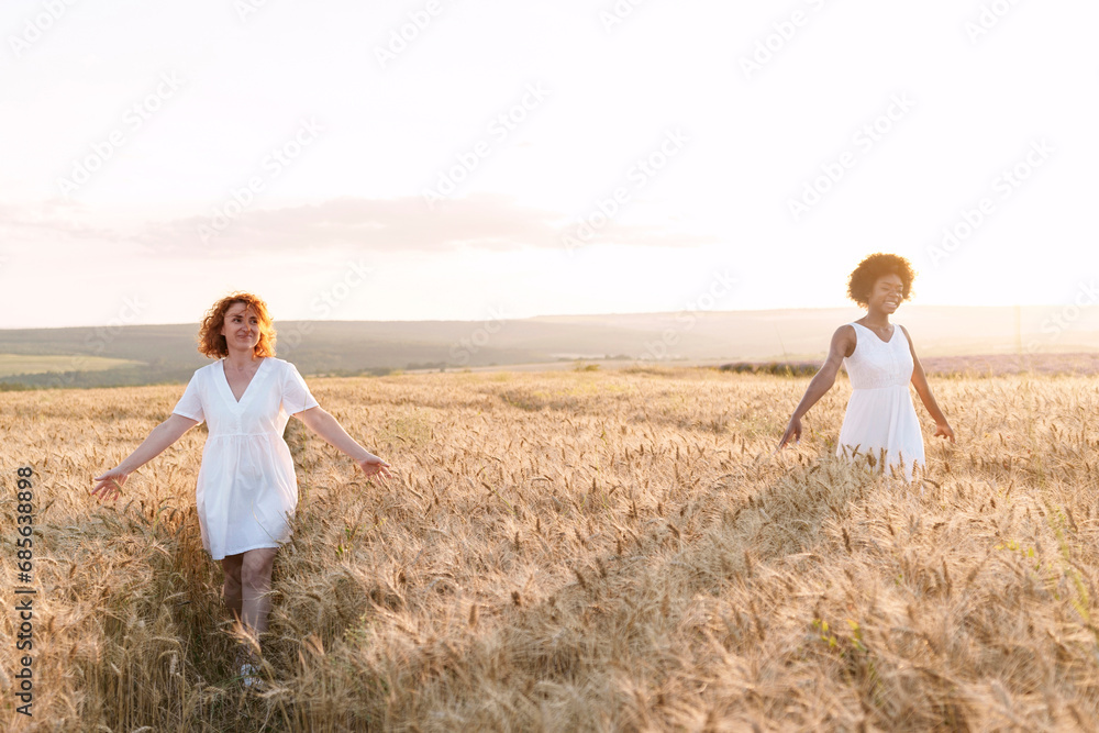 Happy multiracial friends walking in wheat field Happy multiracial friends walking in wheat field