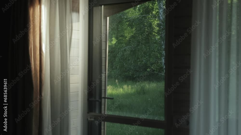 The beautiful view from the cabin house window of the picturesque nature with beautiful trees, green forest out the window. Relax, peaceful place, picturesque nature outside the window, slow motion The beautiful view from the cabin house window of the picturesque nature with beautiful trees, green forest out the window. Relax, peaceful place, picturesque nature outside the window, slow motion