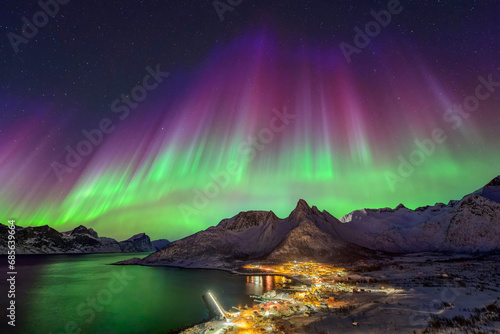 Norway, Troms og Finnmark, Mefjordvaer, Northern lights over remote fishing village on Senja island photo