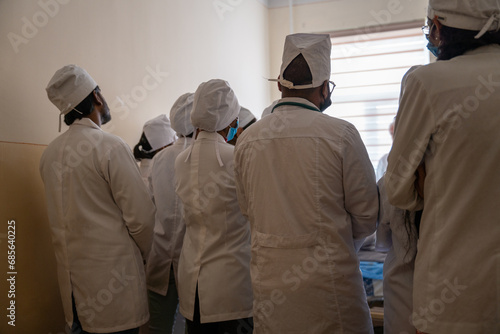 a patient room with the junior doctors listening to the higher professor teaching