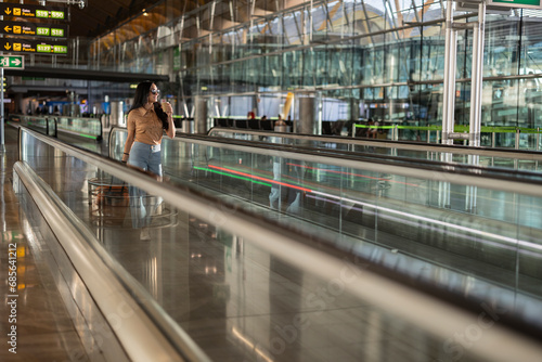 Young woman moving on travelator at airport photo