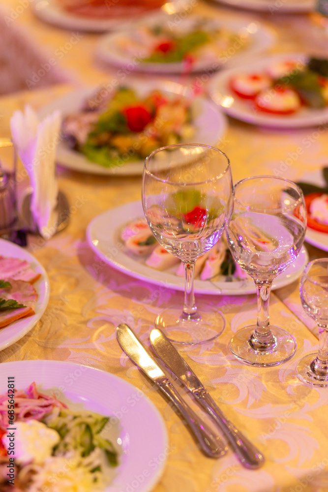 Served festive table with snacks, glasses, glasses, cutlery and napkins for a banquet