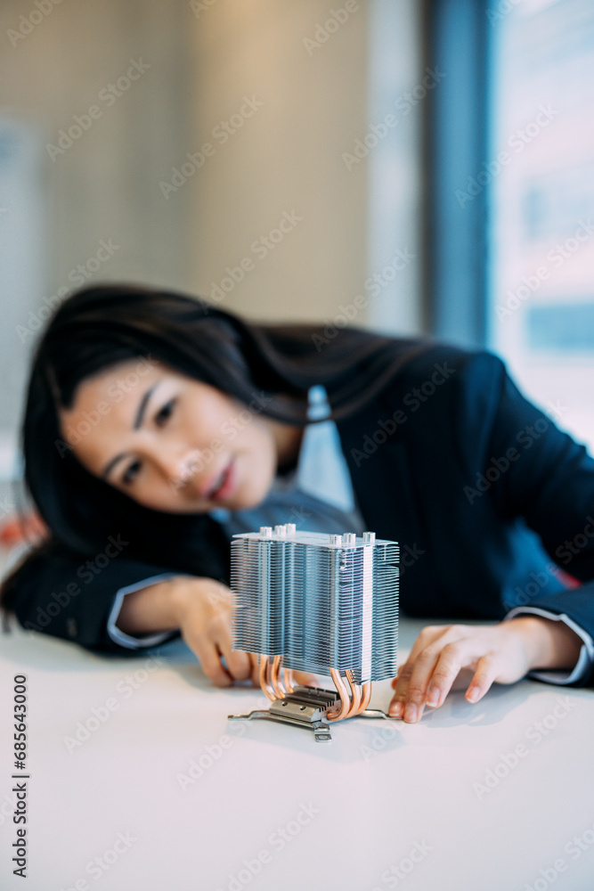 Engineer analyzing semiconductor at desk in office Engineer analyzing semiconductor at desk in office