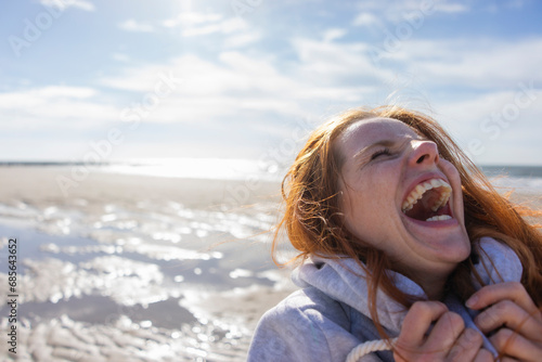 Woman laughing at beach on vacation photo