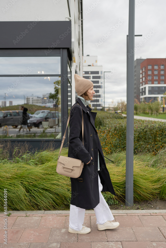 Woman walking with sling bag on sidewalk Woman walking with sling bag on sidewalk