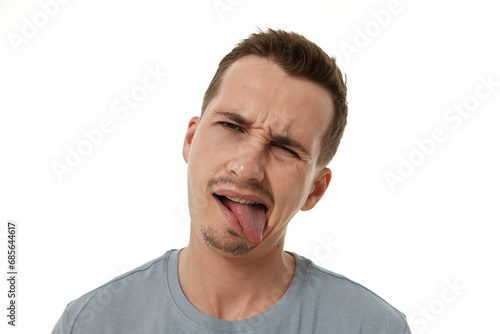 young man shows her toung, feels disgust on white background.