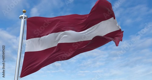 Latvia flag with flagpole waving in wind, rolling clouds background looping, 4K video (Perfect Loop) photo