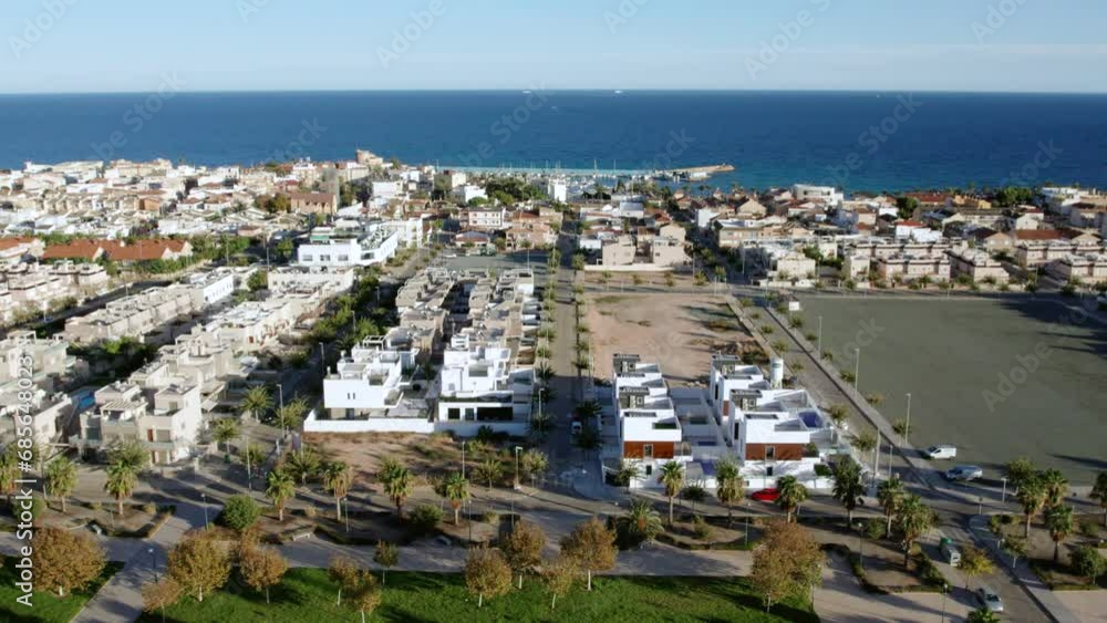 Torre de la Horadada sandy beach, view from above. Drone point of view of harbor with moored yachts and boats residential houses rooftops at sunny day. Costa Blanca, Alicante, Spain. Travel concept Torre de la Horadada sandy beach, view from above. Drone point of view of harbor with moored yachts and boats residential houses rooftops at sunny day. Costa Blanca, Alicante, Spain. Travel concept