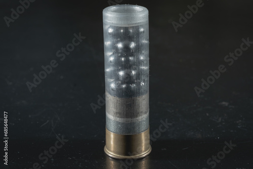 Macro photo of a 12-gauge cartridge with a charge of buckshot, a transparent plastic case.
