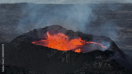 Icelands fire giant awakens and spews lava and ash across the land, aerial drone video photo