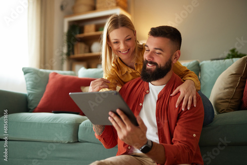 Handsome couple relaxing at home and looking at tablet photo