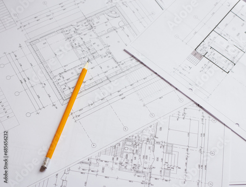 pencil and office tools for writing on the blueprint of construction industry. Place the rolls on a desk over blurred blueprint for construction industry background. © Ryzhkov Oleksandr