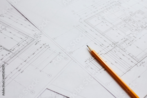 pencil and office tools for writing on the blueprint of construction industry. Place the rolls on a desk over blurred blueprint for construction industry background. © Ryzhkov Oleksandr