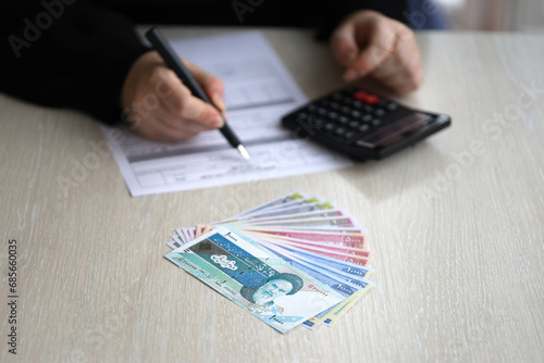 Accountant start to fill Iranian tax form on office table. Taxation period and annual taxpayers routine in Iran photo