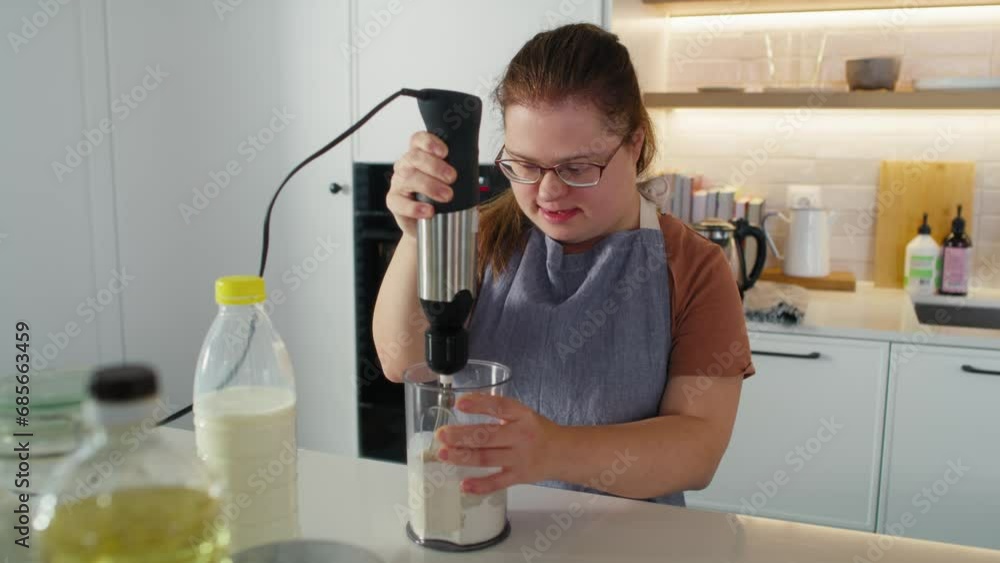 Down syndrome woman baking in domestic kitchen. Shot with RED helium camera in 8K. Down syndrome woman baking in domestic kitchen. Shot with RED helium camera in 8K.