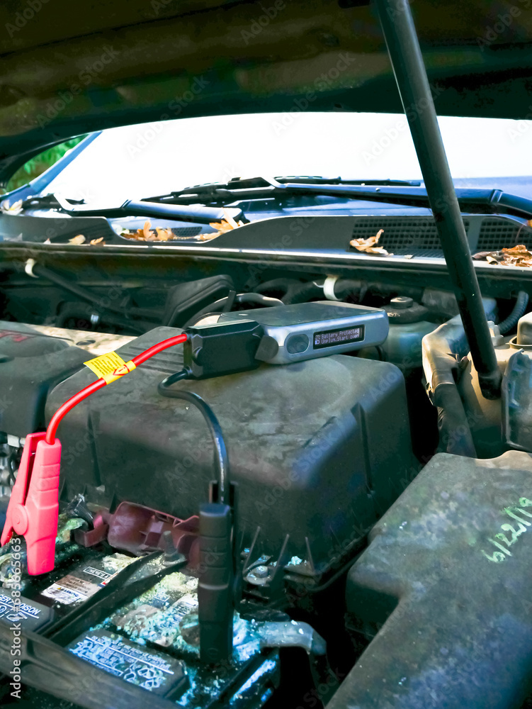 Alligator clips connected to dead corrosion battery with jump starter