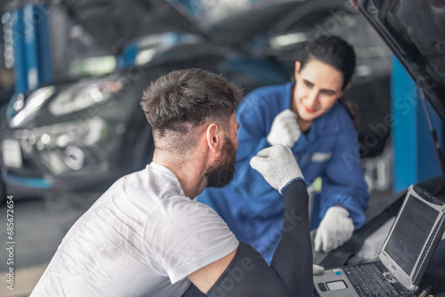 Car technician use computerized diagnostic to analyze, fix, repair engine, ensuring top performance