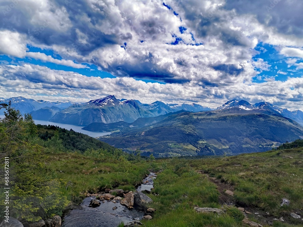 Epic cloudscape over mountain peaks and fjord