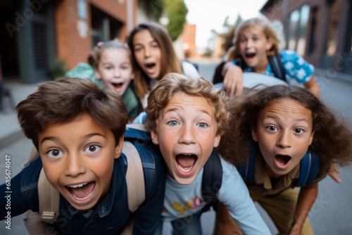 Portrait of happy group of school kids looking at camera and laughing © koala studio