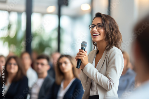 Portrait of a beautiful young businesswoman speaking into microphone during seminar